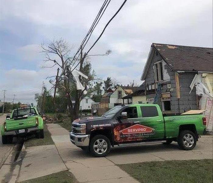 Pictured are destroyed houses and two SERVPRO vehicles in the front.